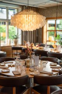 a dining room with a table with chairs and a chandelier at Hestraviken Hotell & Spa in Hestra