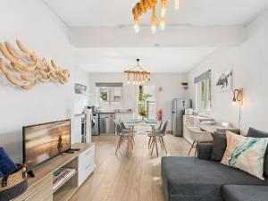 a living room with a couch and a tv and a kitchen at Amis Apartments Mauritius in Cap Malheureux