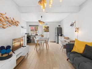 a living room with a couch and a tv and a kitchen at Amis Apartments Mauritius in Cap Malheureux