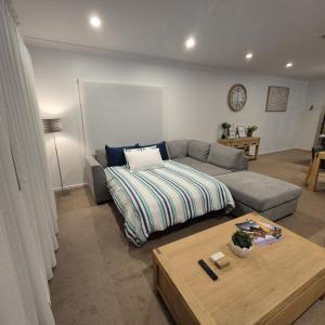 a living room with a couch and a table at 19th Hole Golf, Wine & Sea in Normanville +36 photos