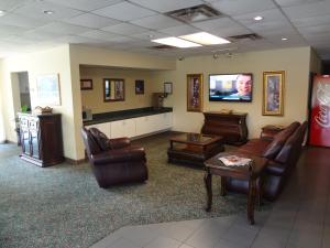 a waiting room with leather furniture and a flat screen tv at Best Inn Formerly Known as M Star Hotel in Chickasaw