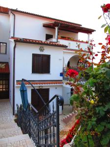 a white house with a black gate and flowers at Villa Milan in Vinkuran