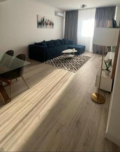 a living room with a blue couch and a table at Mareea Luxury Apartment-Energia Residence in Constanţa