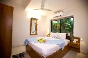 a bedroom with a large bed with a window at 4BHK Villa in Anjuna with private Jacuzzi and pool, 1KM from beach in Anjuna +22 photos