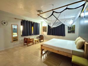 a bedroom with a large bed and a table and chairs at Ngaali Nest in Entebbe
