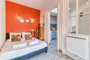 a bedroom with a bed with an orange wall at Golden Bridge - Confort - Calme - Centre in Abbeville