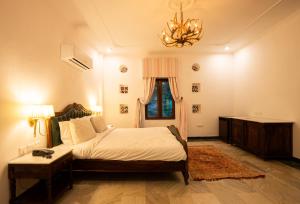 a bedroom with a bed and a chandelier at Medieval Forts & palaces in Pachār