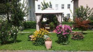 einen Garten mit einem Pavillon mit Blumen im Gras in der Unterkunft Haus Rosegger in Feldkirch