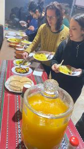a group of people sitting at a table eating food at Rum Jordan camp and tours in Wadi Rum +181 photos
