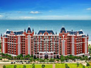 潘切Mövenpick Resort Phan Thiet的一座以海洋为背景的大型度假村建筑