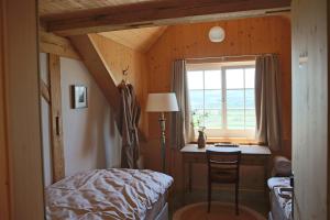 a bedroom with a bed and a desk and a window at Gasthaus Haldenhof in Märstetten