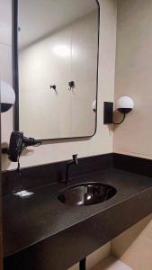 a bathroom with a sink and a mirror at Hotel Lagoa in Laguna
