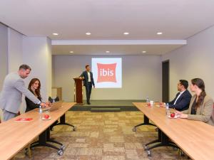 un groupe de personnes assises autour de tables dans une pièce dans l'établissement ibis Doha, à Doha 121 autres photos