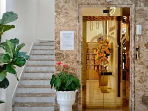 a lobby with stairs and a door with plants at La Pense'e Hotel - Dalat in Da Lat +125 photos