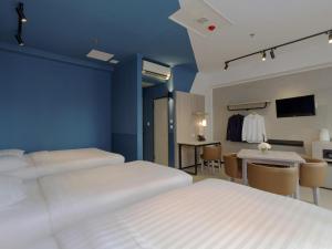 a hotel room with two beds and a table and a kitchen at ibis budget Phnom Penh Riverside in Phnom Penh