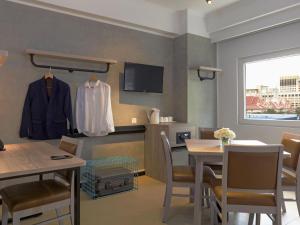 a room with a table and a coat hanging on a wall at ibis budget Phnom Penh Riverside in Phnom Penh