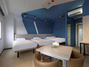 a room with three beds and a table with flowers on it at ibis budget Phnom Penh Riverside in Phnom Penh +27 photos