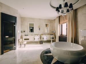 uma casa de banho com um lavatório, 2 lavatórios e uma banheira em Rixos Borovoe em Borovoe mais 148 fotografias