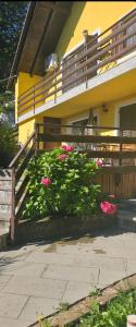 a house with pink flowers in front of a fence at Apartman Green Dream Fužine in Fužine