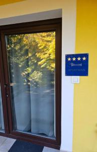 a glass door with a blue sign with stars on it at Apartman Green Dream Fužine in Fužine