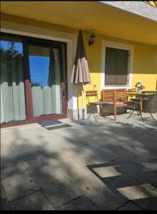 a house with a patio with an umbrella and a table at Apartman Green Dream Fužine in Fužine