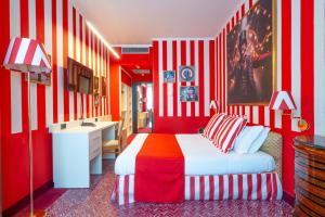 a red and white bedroom with a bed and a desk at Admiral Art Hotel in Rimini