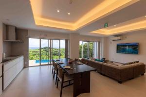 Miyakojima宮古島の美しい海と自然を一望できる絶景リゾートヴィラ的带沙发和桌子的客厅