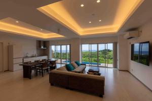 Miyakojima宮古島の美しい海と自然を一望できる絶景リゾートヴィラ的配有沙发和桌子的大客厅