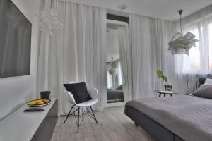 biała sypialnia z łóżkiem i białym krzesłem w obiekcie Apartament Zbożowy Rynek 2 w Bydgoszczy