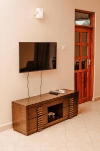 un salon avec une télévision au mur dans l'établissement Xpine lobster, à Dar es Salaam