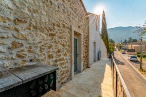 a stone building with a sidewalk next to a street at Canto Cigalo Duplex 12 in Robion en Luberon