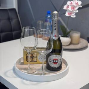 a tray with two glasses and a bottle of wine at Komfort MazuryBase in Ostróda