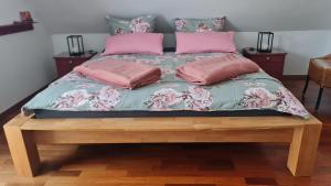 een bed met roze en roze kussens erop bij Ferienhaus Rosengarten in Selb