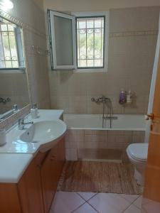 a bathroom with a sink and a tub and a toilet at Holiday House Sonia in Didyma +15 photos