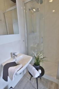 a white bathroom with a sink and a shower at Apartament Zbożowy Rynek 2 in Bydgoszcz