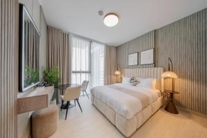 a bedroom with a bed and a desk and a table at 1BR Luxury Suite at Misk - Aljada Center - 2WC in Sharjah