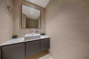a bathroom with a sink and a mirror at 1BR Luxury Suite at Misk - Aljada Center - 2WC in Sharjah +33 photos