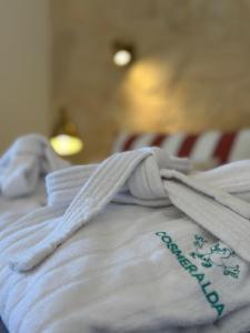 a close up of a white blanket on a bed at Residence SardegnaSummer Li Cuppulati in San Teodoro +53 photos