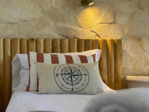 a bed with a white pillow with a wooden headboard at Residence SardegnaSummer Li Cuppulati in San Teodoro
