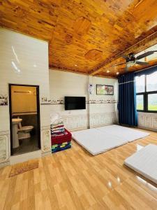 Cette grande chambre comprend deux lits et une télévision. dans l'établissement Happy Heart Homestay - Nhà số 07 bản Lác, à Mai Châu
