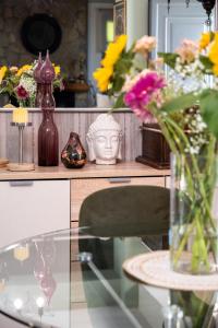 une table en verre avec un vase de fleurs dessus dans l'établissement The Moon House, à Prévéza