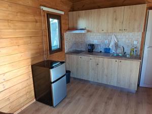 a kitchen with wooden walls and a refrigerator and a counter at Eco Wooden Olympic view Village in Leptokaria