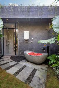 a bath tub sitting in the middle of a garden at The Garden Villas in Ubud