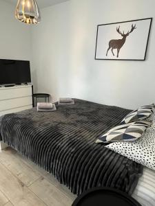 a bedroom with a bed with a deer on the wall at Apartament Fibra Americano in Rybnik