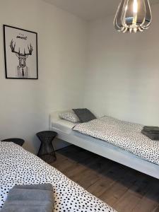 a room with two beds and a picture of a deer on the wall at Apartament Fibra Americano in Rybnik