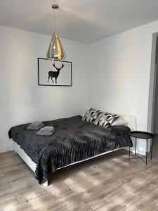 a bedroom with a bed with a black comforter at Apartament Fibra Americano in Rybnik
