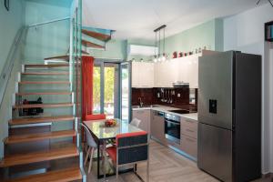 une cuisine avec un escalier, une table et un réfrigérateur dans l'établissement The Moon House, à Prévéza
