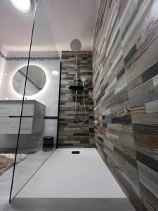 ein Bad mit einer Dusche und einer Fliesenwand in der Unterkunft Adosado La Dolce Vita in Molinell