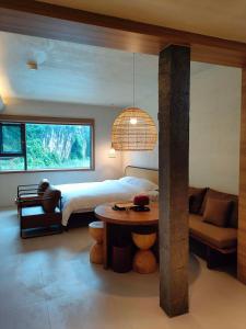 a bedroom with a bed and a table and a couch at NO.9 Alley Yuchen Res Dence in Guilin