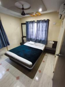 a bedroom with a large bed with a blue blanket at Hotel shivalay in Dwarka